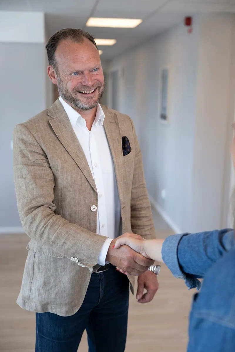 Fredrick hälsar på en besökare i en korridor